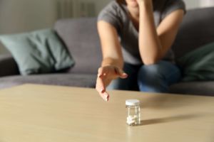 woman reaching for pills to deal with past trauma